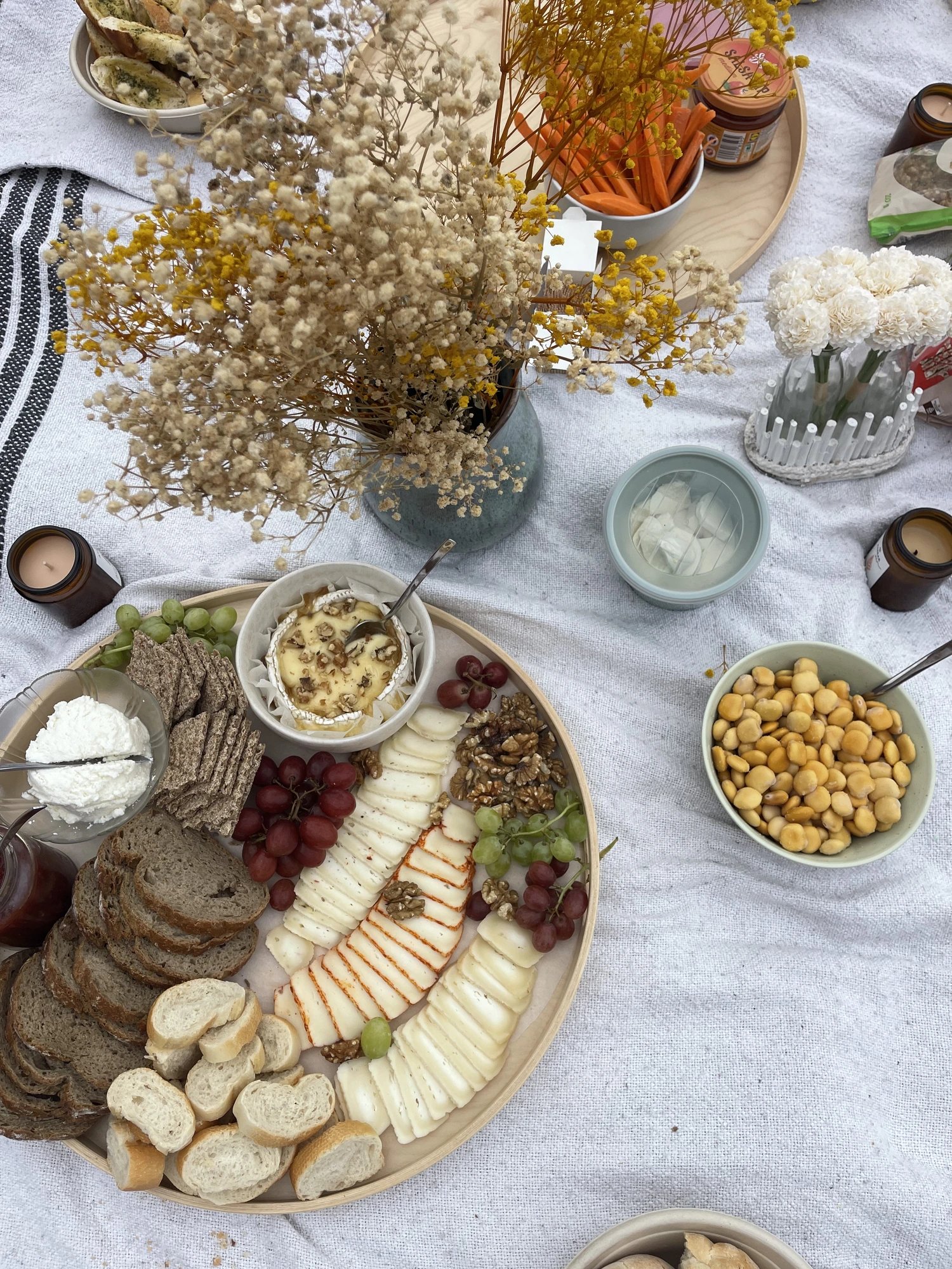 Tapas platter with cheese, bread, grapes and dried flowers